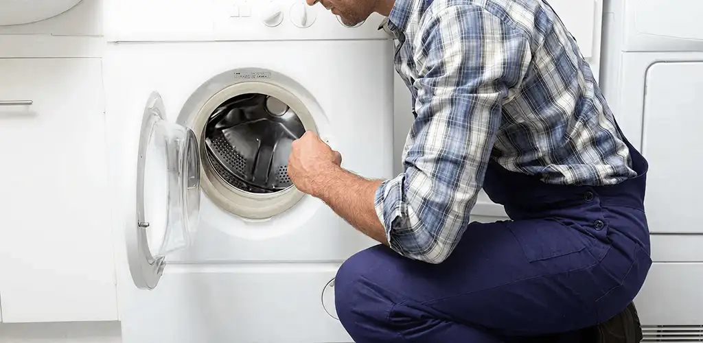 Handyman inspecting a dryer drum and internal parts for repair in Birmingham, AL
