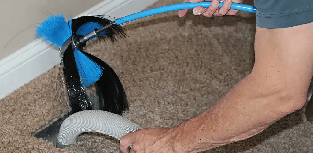 Dryer vent cleaning technician brushing lint from a vent line in Birmingham, AL