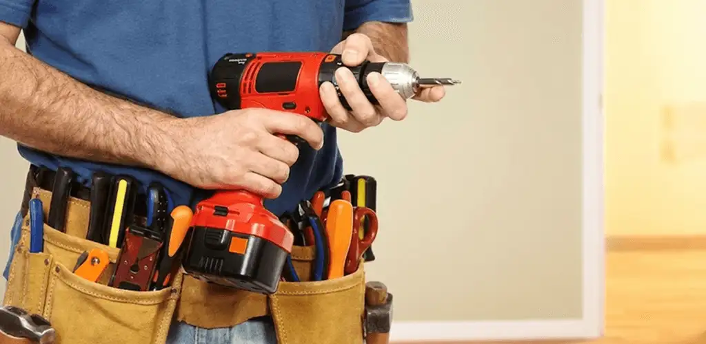 Handyman holding a power drill for home repairs and installations in Birmingham, AL