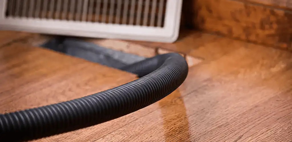 Air duct cleaning hose inserted into a floor vent for ductwork cleaning in Birmingham, AL
