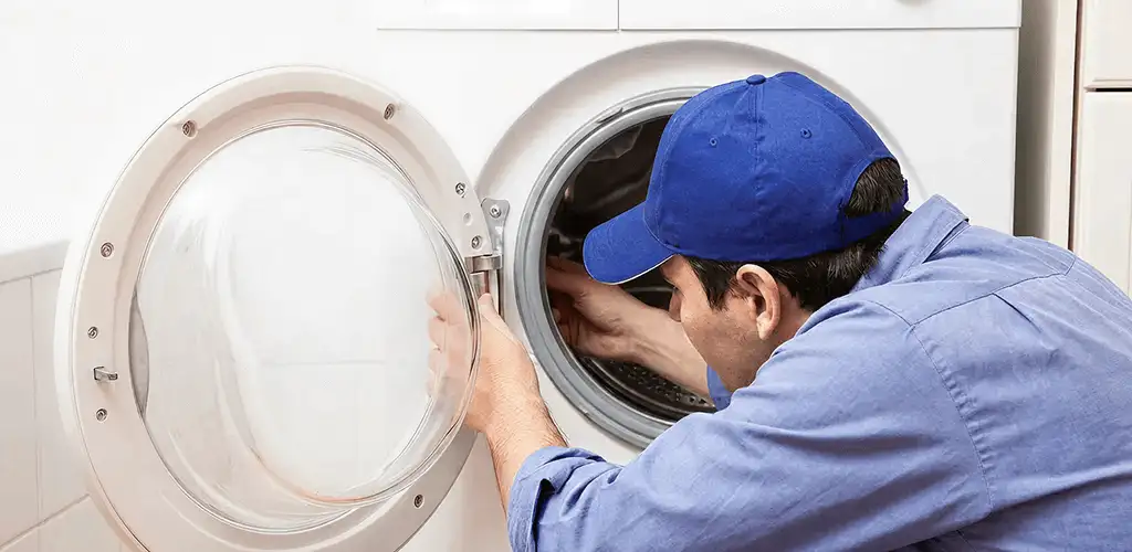 Washing machine repair handyman inspecting a front-load washer drum in Birmingham, AL